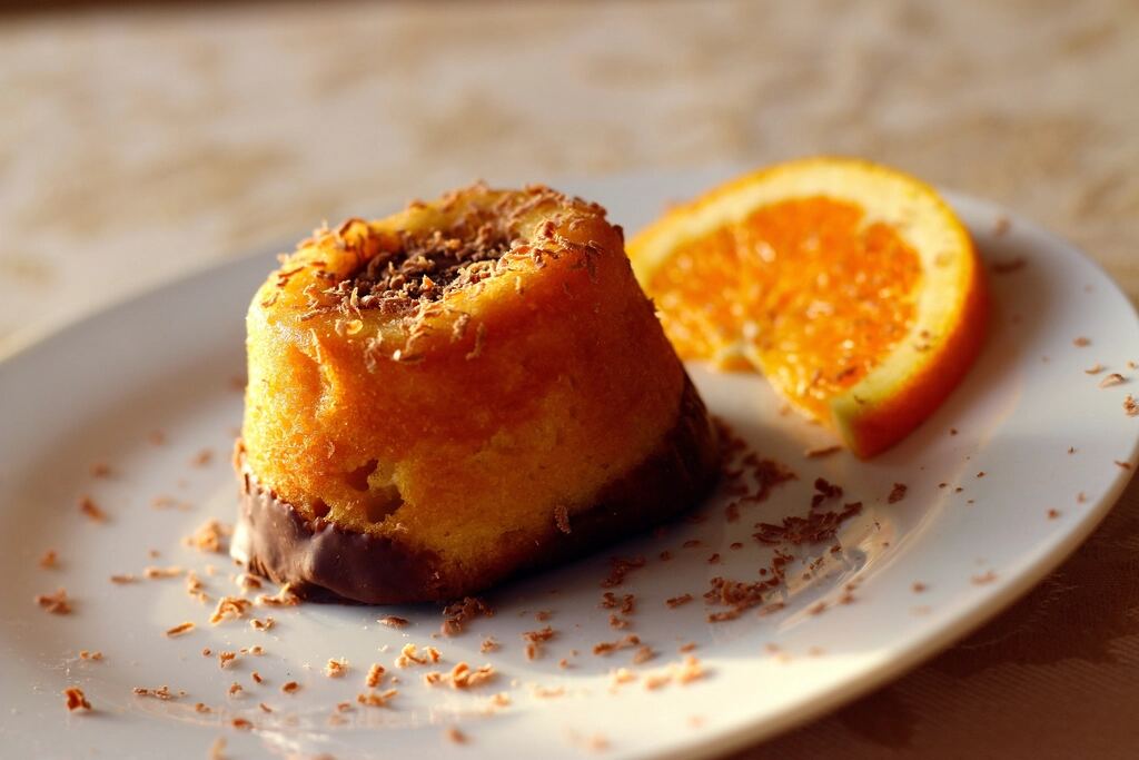 Golden orange cake with a slice of orange and grated chocolate