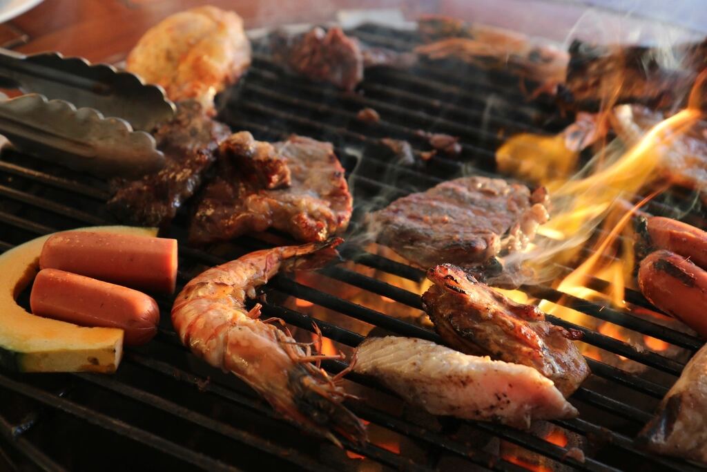 Meat and vegetables grilling over open flames
