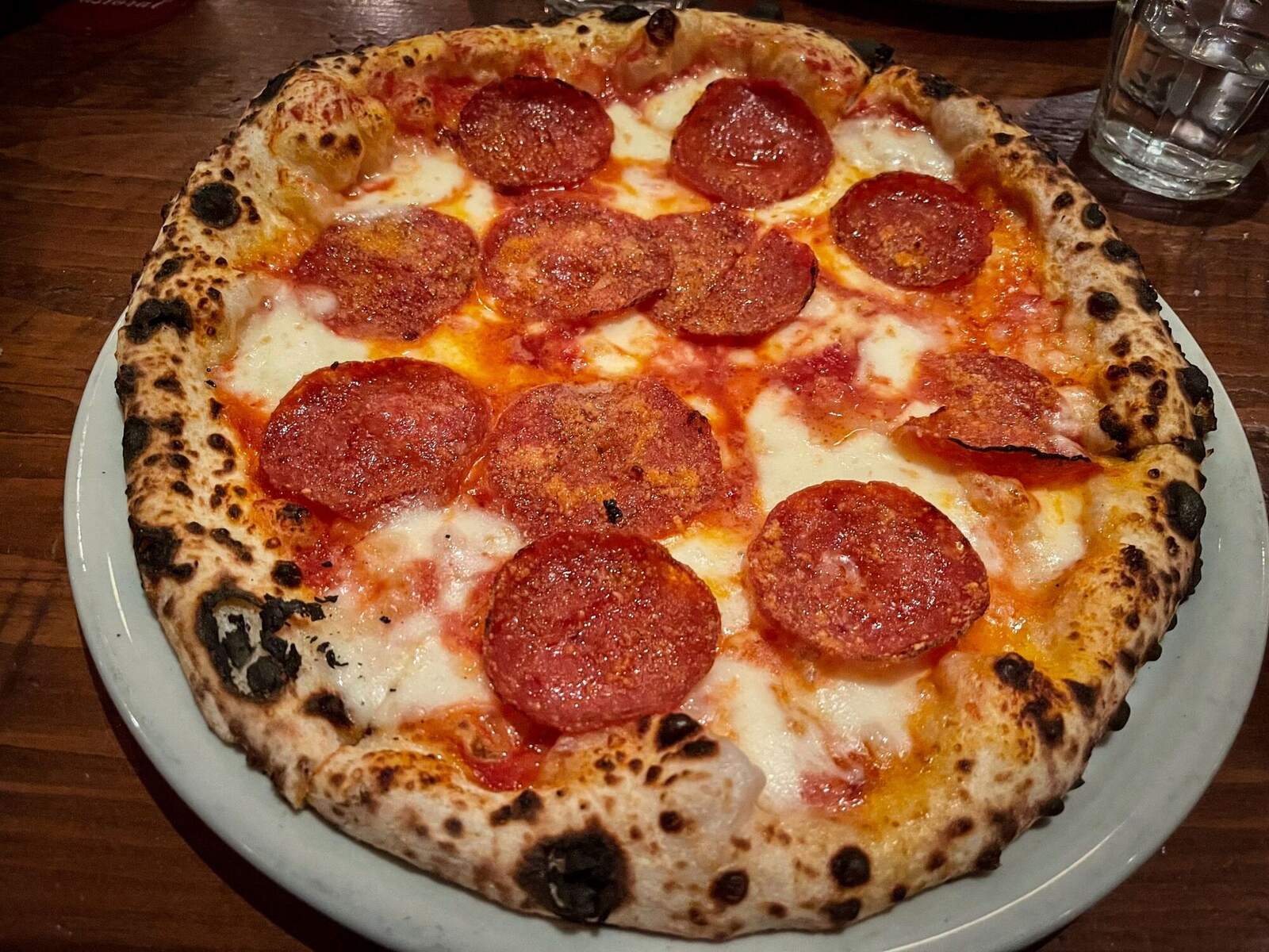 A wood-fired flatbread with a blistered, charred crust